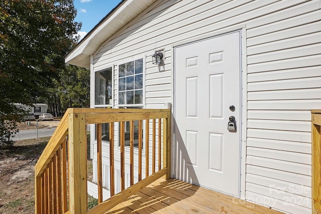 view of exterior entry featuring a wooden deck