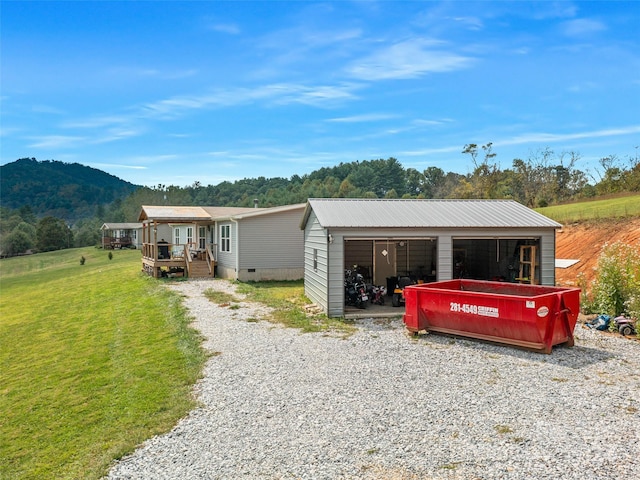 exterior space featuring a front lawn, an outdoor structure, and a deck with mountain view