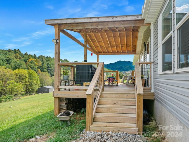 wooden deck featuring a yard and a mountain view