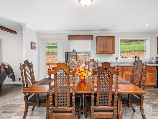 dining area featuring crown molding and light carpet