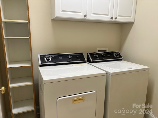 washroom featuring separate washer and dryer and cabinets