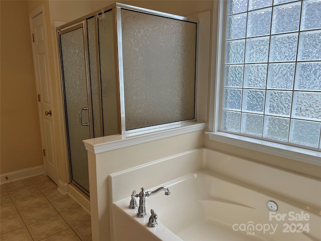 bathroom featuring plus walk in shower and tile patterned flooring