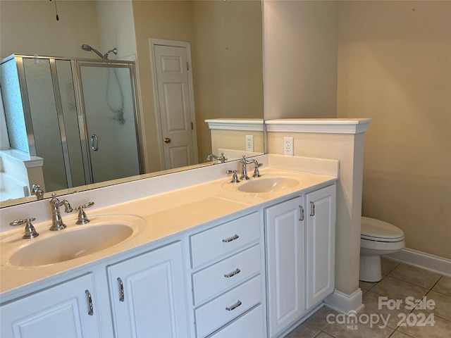 bathroom with vanity, toilet, tile patterned flooring, and a shower with door