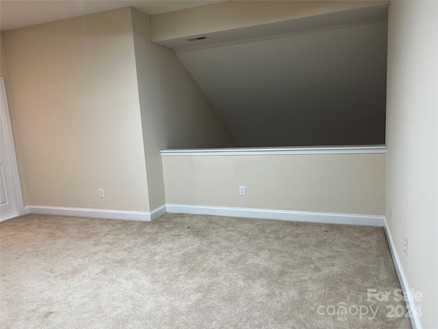 unfurnished room with vaulted ceiling and light carpet