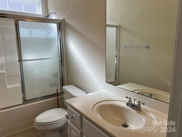 full bathroom featuring tile patterned flooring, vanity, toilet, and combined bath / shower with glass door