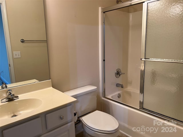 full bathroom with enclosed tub / shower combo, vanity, and toilet