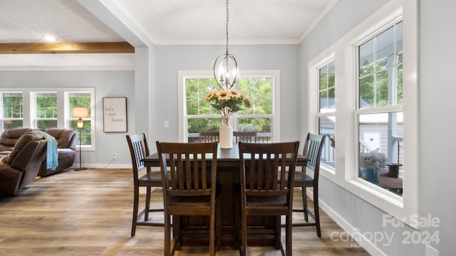 dining area featuring crown molding, beamed ceiling, a chandelier, and hardwood / wood-style flooring