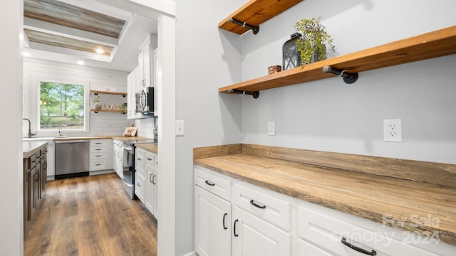 kitchen with white cabinetry, dark hardwood / wood-style flooring, stainless steel appliances, and light stone counters