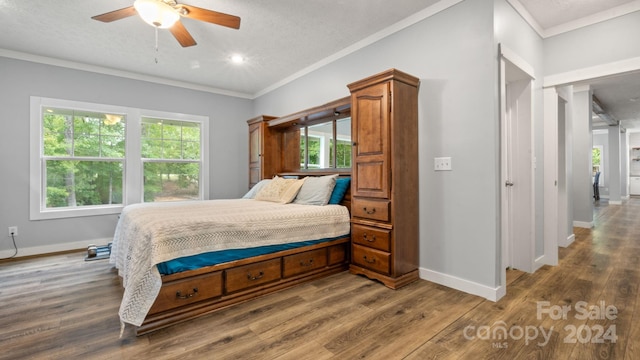 bedroom with a textured ceiling, hardwood / wood-style floors, and multiple windows