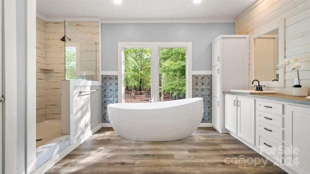 bathroom featuring wooden walls, shower with separate bathtub, vanity, and hardwood / wood-style flooring