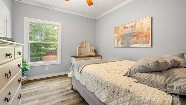 bedroom with light wood-type flooring, ornamental molding, and ceiling fan