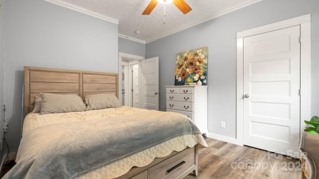 bedroom with ceiling fan, hardwood / wood-style flooring, crown molding, and a textured ceiling