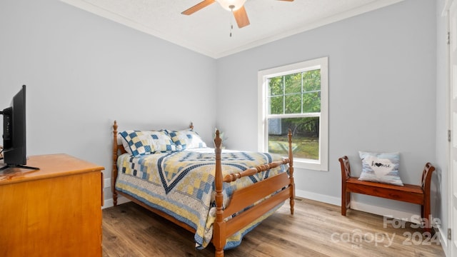 bedroom featuring ceiling fan, hardwood / wood-style flooring, and crown molding