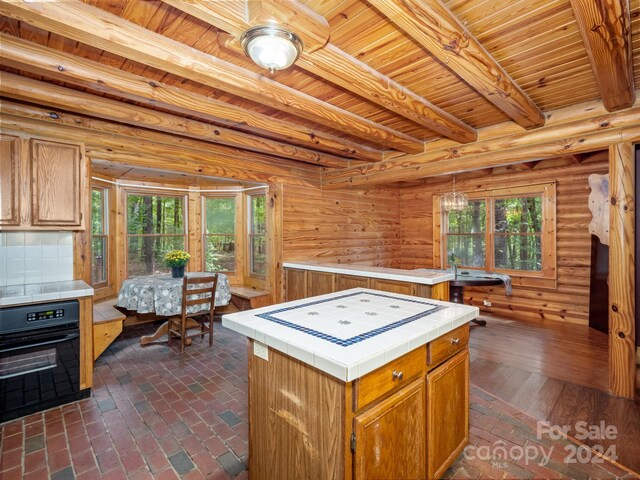 kitchen featuring tasteful backsplash, dark wood-type flooring, oven, tile countertops, and a center island