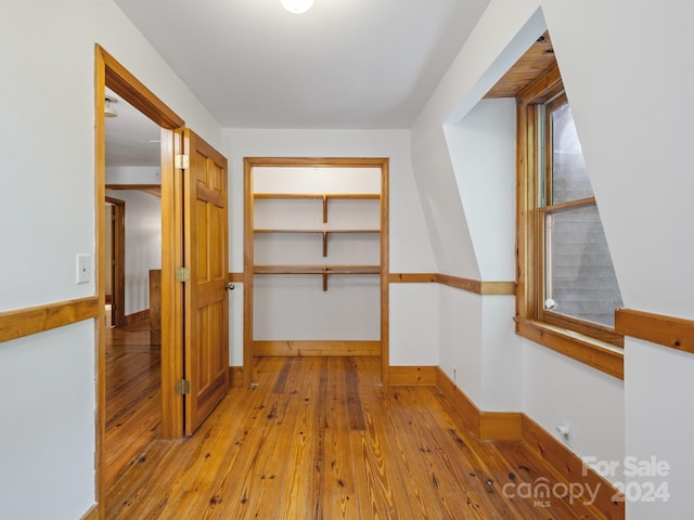 walk in closet with light hardwood / wood-style floors