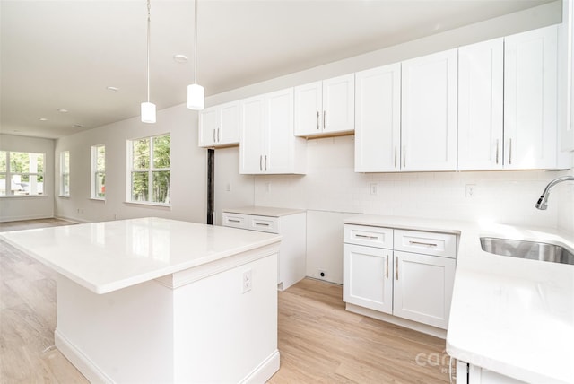 kitchen with white cabinets, sink, and a center island