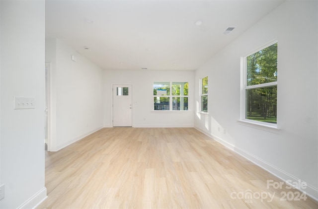 spare room with a wealth of natural light and light hardwood / wood-style flooring