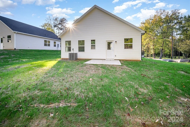 rear view of property with a patio, a yard, and central air condition unit