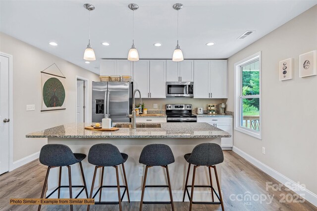 376 Hague Dr, Columbus, NC 28722 - kitchen with stainless steel appliances, a sink, a breakfast bar area, light wood-style floors, and recessed lighting