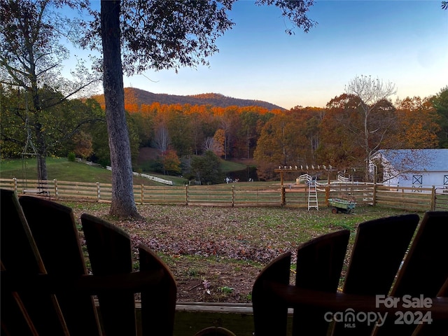 yard at dusk featuring a rural view