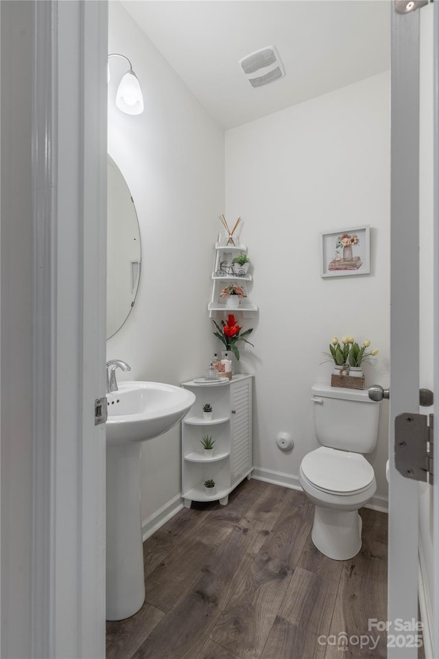 bathroom featuring hardwood / wood-style flooring and toilet