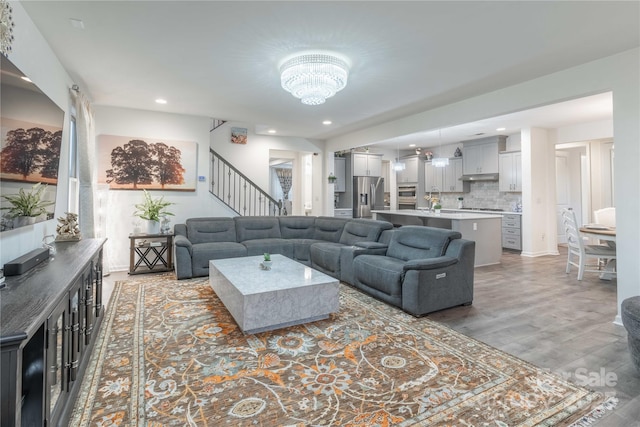 living room with hardwood / wood-style floors and a notable chandelier