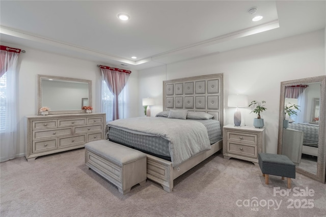 carpeted bedroom with a tray ceiling