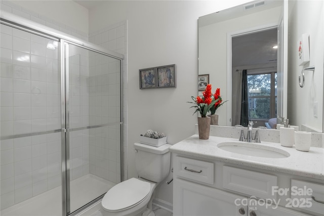 bathroom with toilet, vanity, and walk in shower