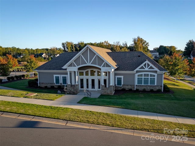 craftsman house featuring a front lawn and french doors