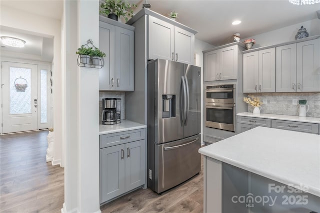 kitchen featuring backsplash, gray cabinets, and stainless steel appliances