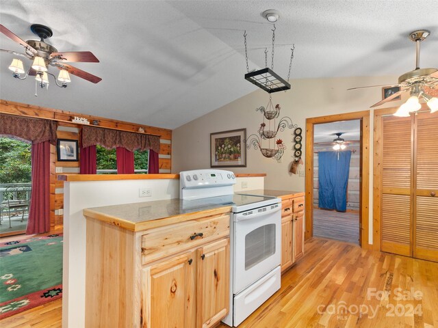 kitchen with light brown cabinetry, electric range, lofted ceiling, and ceiling fan