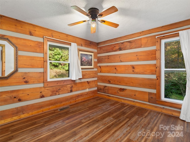 229 Medford Hannah Rd, Waynesville, NC 28785 - spare room with wood walls, healthy amount of natural light, a textured ceiling, wood finished floors, and a ceiling fan