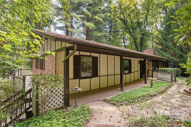 1010 Indian Hill Rd, Hendersonville, NC 28791 - view of property exterior with board and batten siding, a chimney, and brick siding