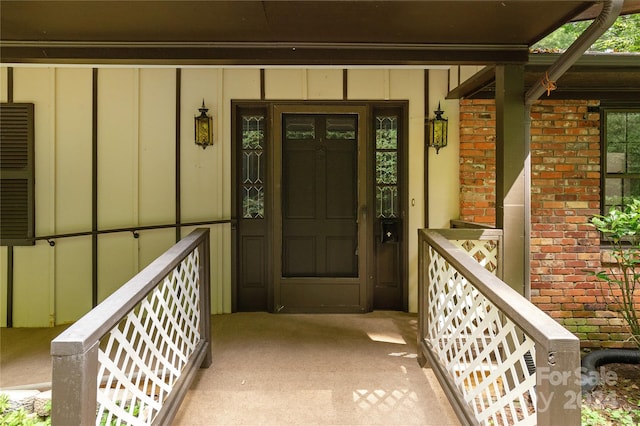 1010 Indian Hill Rd, Hendersonville, NC 28791 - view of exterior entry featuring board and batten siding, brick siding, and a porch