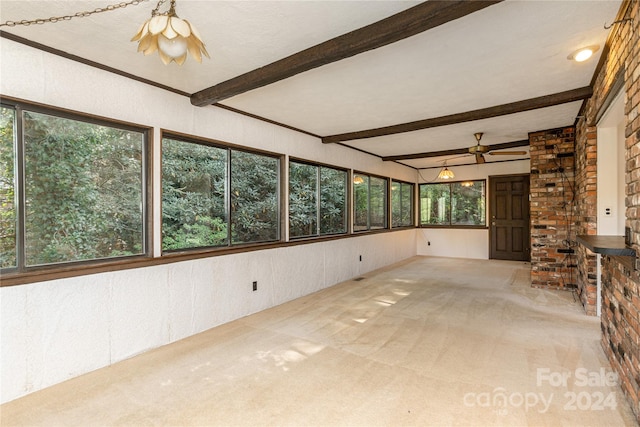 unfurnished sunroom with beam ceiling and ceiling fan