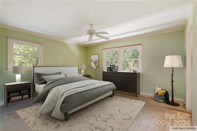 carpeted bedroom featuring multiple windows, ceiling fan, and crown molding