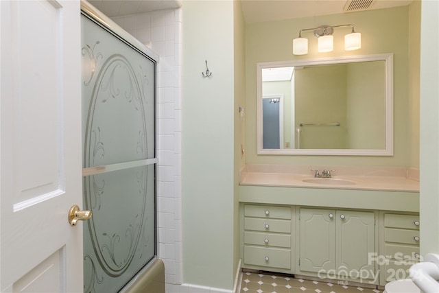 bathroom with vanity and bath / shower combo with glass door