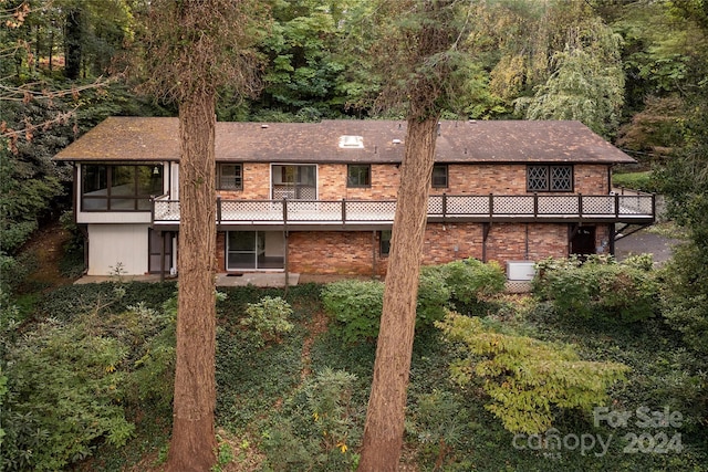1010 Indian Hill Rd, Hendersonville, NC 28791 - view of side of property with brick siding, a view of trees, and a balcony