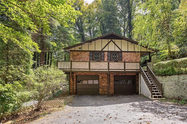 1010 Indian Hill Rd, Hendersonville, NC 28791 - view of front of house with board and batten siding, brick siding, asphalt driveway, and an attached garage