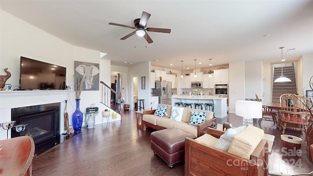 living room featuring ceiling fan and dark hardwood / wood-style floors