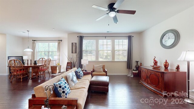 living room featuring dark hardwood / wood-style flooring, ceiling fan, and a healthy amount of sunlight