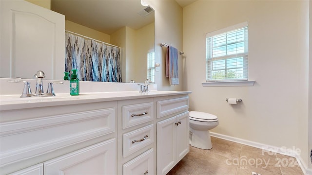 bathroom featuring tile patterned flooring, vanity, and toilet