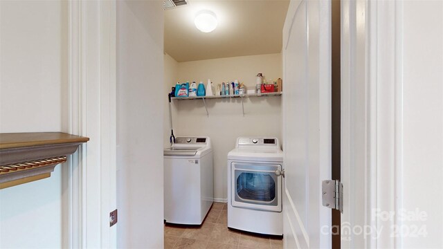 washroom with separate washer and dryer and light tile patterned floors