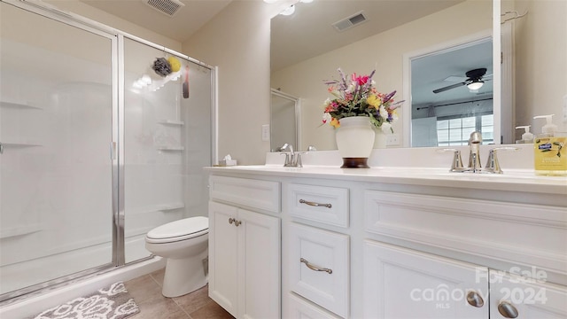 bathroom with tile patterned floors, an enclosed shower, vanity, ceiling fan, and toilet