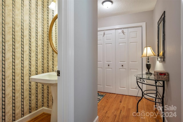 corridor featuring hardwood / wood-style floors and a textured ceiling