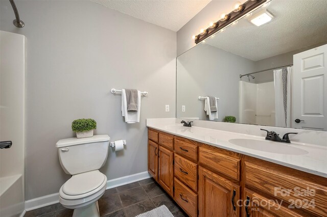 29 Daves Rd, Mooresboro, NC 28114 - bathroom with baseboards, a textured ceiling, toilet, double vanity, and stone finish flooring