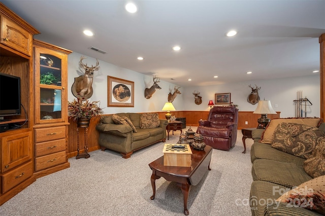 living room featuring wood walls and light carpet