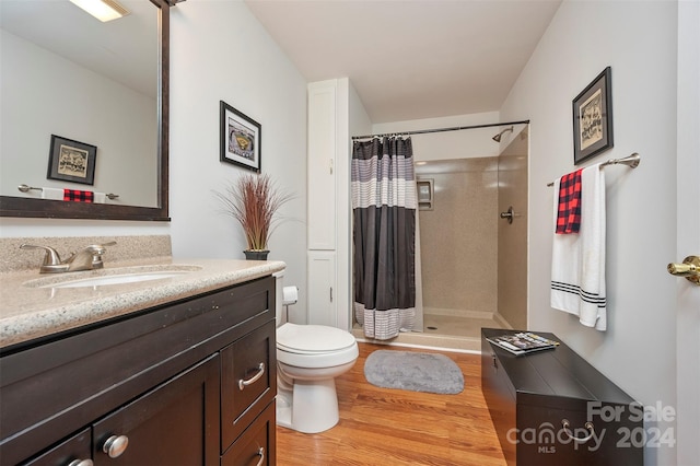 bathroom featuring toilet, vanity, hardwood / wood-style flooring, and a shower with shower curtain