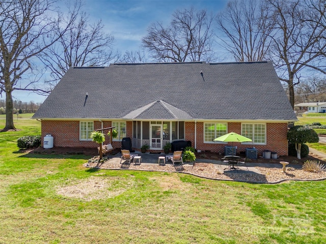 rear view of property featuring a lawn and a patio area