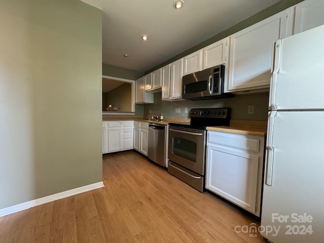 kitchen featuring appliances with stainless steel finishes, light wood-type flooring, and white cabinetry